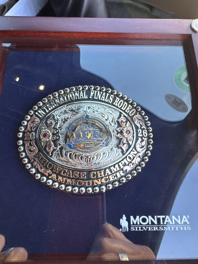 Montana Silversmiths buckle in a display case, engraved International Finals Rodeo, 2026, Showcase Champion Announcer.